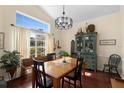 Bright dining room featuring wood floors, a large window, and a vintage china cabinet at 4199 Conway Place Cir, Orlando, FL 32812