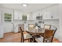 Modern kitchen with white cabinets, stainless steel appliances, and a cozy dining area with stylish lighting at 4922 Huppel Ave, Orlando, FL 32811