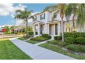 Inviting townhome with palm trees, showcasing maintained lawns and accessible sidewalks, great for community living at 6013 Blue Lily Way, Winter Garden, FL 34787