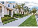 Attractive townhome showcasing a neat sidewalk and well-manicured greenery, offering a pleasant curb appeal at 6013 Blue Lily Way, Winter Garden, FL 34787