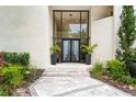Elegant entrance featuring a grand glass door and manicured landscaping at 608 E Club Cir, Longwood, FL 32779