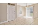 Entryway with neutral tile flooring, white door, and light fixtures, creating a bright and welcoming space at 6434 S Goldenrod Rd # 17B, Orlando, FL 32822
