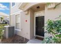 Image shows the home's front entrance and door, with adjacent window, AC unit, and greenery at 6434 S Goldenrod Rd # 17B, Orlando, FL 32822