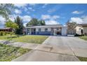 Charming single-story home with a carport, well-maintained lawn, and mature trees at 6464 Inca St, Orlando, FL 32807