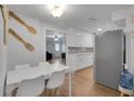 Bright, eat-in kitchen featuring all-white cabinets, stainless steel refrigerator and modern backsplash at 6464 Inca St, Orlando, FL 32807