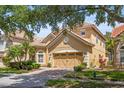 Two-story home with lush front yard landscaping and brick paver driveway, with a classic red-tile roof at 6857 Dolce St, Orlando, FL 32819