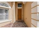 Close-up of front door, featuring wood door with decorative details and brick paver walkway at 6857 Dolce St, Orlando, FL 32819