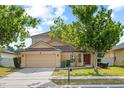 Two-story home featuring a well-manicured lawn, mature shade trees, and attached two-car garage at 802 Pickfair Ter, Lake Mary, FL 32746