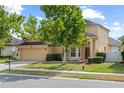 Two-story home featuring a well-manicured lawn, mature shade trees, and attached two-car garage at 802 Pickfair Ter, Lake Mary, FL 32746