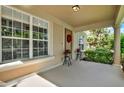 Welcoming front porch featuring decorative plants, a wreath, and natural light at 8448 Greenbank Blvd, Windermere, FL 34786