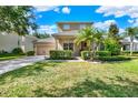 Inviting two-story home with lush front yard, featuring a well-manicured lawn and vibrant landscaping at 8448 Greenbank Blvd, Windermere, FL 34786