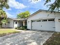 Two-car garage with attached living space and manicured landscaping at 8484 Sandberry Blvd, Orlando, FL 32819
