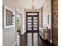 Elegant entryway featuring dark wood floors, a stone accent wall, and decorative lighting at 8581 Lake Nona Shore Dr, Orlando, FL 32827