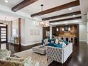 Spacious living room with dark wood floors, high ceilings with exposed beams, and stylish furniture at 8581 Lake Nona Shore Dr, Orlando, FL 32827