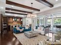 Bright living room with dark wood floors, exposed beams, and seamless indoor-outdoor living space at 8581 Lake Nona Shore Dr, Orlando, FL 32827