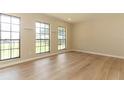 Light-filled bedroom with wood-look flooring and large windows offering ample natural light at 8830 Ladrido Ln, Orlando, FL 32836