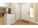 Bright entryway featuring a white front door, wood-look tile flooring, and views of kitchen at 8830 Ladrido Ln, Orlando, FL 32836