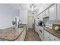 Efficient kitchen with white cabinets, granite countertops, and modern appliances at 911 N Orange Ave # 409, Orlando, FL 32801