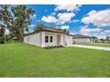 An eye-level view shows the home's well-kept lawn, neutral color palette, manicured landscaping and an attached two-car garage at 9472 Se 152Nd Pl, Summerfield, FL 34491