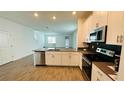 Open-concept kitchen with stainless steel appliances and a breakfast bar at 11296 Listening Dr, Orlando, FL 32832