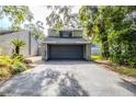View of the home's two car garage, and driveway, with an inviting exterior and lush landscaping at 121 Primrose Dr, Longwood, FL 32779