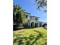 Charming two-story home with a well-manicured lawn and palm trees at 1690 Palm Ave, Winter Park, FL 32789
