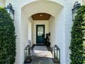 Inviting entryway with a painted brick archway, a teal door, and stylish light fixtures at 1690 Palm Ave, Winter Park, FL 32789