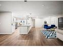 Spacious living room offering an open layout, kitchen view, hardwood floors, and stylish blue chairs at 4032 Doral, Winter Haven, FL 33884