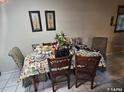 Dining area features tile flooring and traditional decor with a covered table and ornate chairs at 7747 Pine Hawk Ln, Orlando, FL 32822