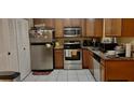 Efficient kitchen with stainless steel appliances, tile floors, and wood cabinets at 7747 Pine Hawk Ln, Orlando, FL 32822