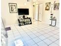Bright living room with tile flooring, tv, and light-colored walls at 7747 Pine Hawk Ln, Orlando, FL 32822