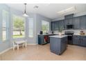 Eat-in kitchen with an island, stainless appliances, and abundant natural light at 12651 Winding Woods Ln, Orlando, FL 32832