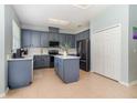 Kitchen featuring an island, stainless appliances, white countertops, and painted blue-gray cabinets at 12651 Winding Woods Ln, Orlando, FL 32832