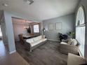 Inviting living room with wood-look tile flooring, neutral colors, and natural light from a large window at 12651 Winding Woods Ln, Orlando, FL 32832