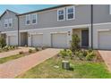 Charming townhome with manicured lawn and brick walkway leading to the front door at 16419 Bird Of Paradise Ave, Clermont, FL 34714