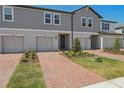Charming townhome with well manicured lawn, brick walkway leading to front door and one car garage at 16419 Bird Of Paradise Ave, Clermont, FL 34714