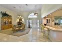 Elegant dining area featuring a chandelier, a china cabinet, and transom windows for natural light at 2446 Sweetwater Country Club Dr, Apopka, FL 32712