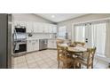 Bright kitchen with white cabinets, stainless steel appliances, tiled backsplash, and a cozy dining area at 360 Coventry Estate Blvd, Deltona, FL 32725