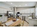 Bright kitchen with white cabinets, stainless steel appliances, tiled backsplash, and a cozy dining area at 360 Coventry Estate Blvd, Deltona, FL 32725