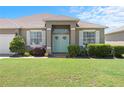 Home featuring a well-manicured lawn, a welcoming front door, and attractive landscaping at 829 Terranova Rd, Winter Haven, FL 33884