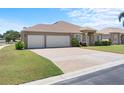 Charming single-story home with a well-manicured lawn, three-car garage, and welcoming entryway at 829 Terranova Rd, Winter Haven, FL 33884