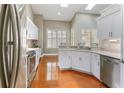 Bright kitchen featuring stainless steel appliances, white cabinets, granite countertops, and hardwood floors at 1403 Valley Pine Cir, Apopka, FL 32712