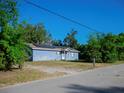 Charming single-story home featuring a blue exterior, solar panels, a well-kept lawn, and a double-door entrance at 15 Estrella Rd, Debary, FL 32713