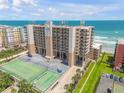 Coastal condo building features a tennis court, parking, and balconies overlooking the ocean at 4139 S Atlantic Ave # B707, New Smyrna Beach, FL 32169