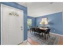 Dining room featuring blue walls, a modern table set, and natural light from the nearby window at 4306 Pebblestone Ct, Orlando, FL 32826
