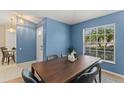 Dining room with a window and a dark wooden table set against the blue walls at 4306 Pebblestone Ct, Orlando, FL 32826