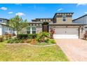 Charming two-story home with brick driveway, two-car garage, stone accents, and lush landscaping at 5637 Beggs Road, St Cloud, FL 34771