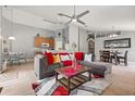 Open-concept living room with a gray sofa, a ceiling fan, and access to the kitchen and dining area at 650 Old Bridge Cir, Davenport, FL 33897
