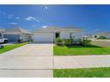 Inviting single-story home with a well-kept lawn, driveway, and landscaped front yard on a clear day at 820 Overpool Ave, Davenport, FL 33896