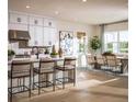 Bright, open-concept kitchen featuring white cabinetry, stainless steel appliances, and an adjacent dining area at 9429 Golden Laurel Ln, Orlando, FL 32827